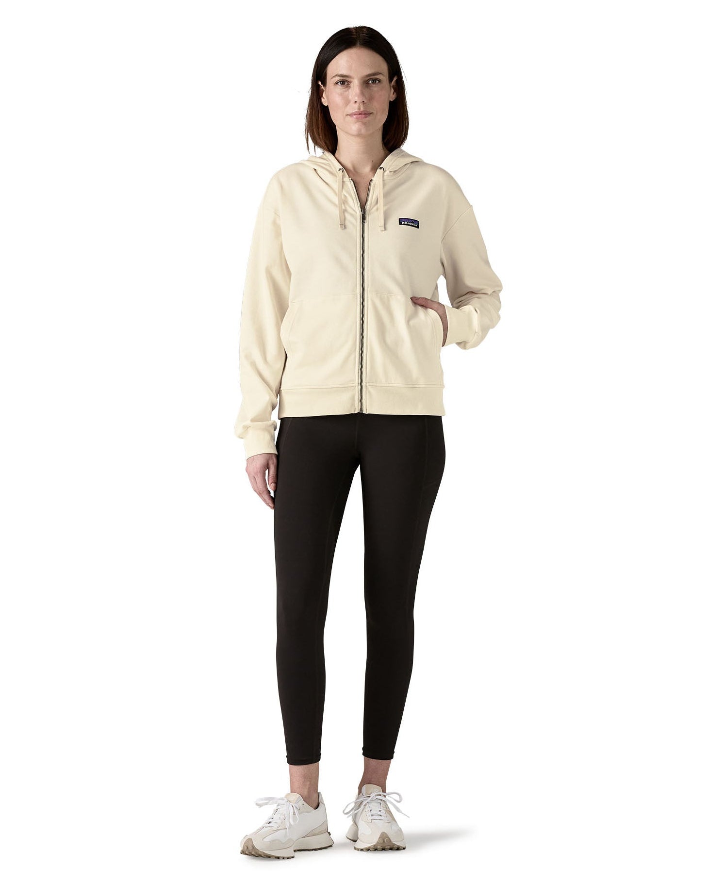 Woman wearing Patagonia's women's Anhya hoody with full front zip and a hand in the pouch pocket
