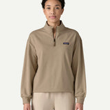 Front view of a woman wearing the Patagonia Women’s Ahnya Pullover in Seabird Grey, featuring the 1/4 zip collar, kangaroo handwarmer pockets and small Patagonia logo on the left chest.