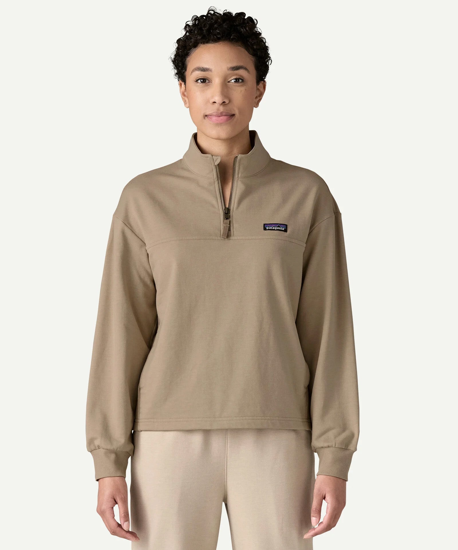Front view of a woman wearing the Patagonia Women’s Ahnya Pullover in Seabird Grey, featuring the 1/4 zip collar, kangaroo handwarmer pockets and small Patagonia logo on the left chest.
