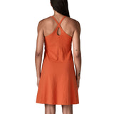 Back of woman wearing Patagonia's amber dawn sleeveless dress in orange.  Dress is slim fit and classic knee-height