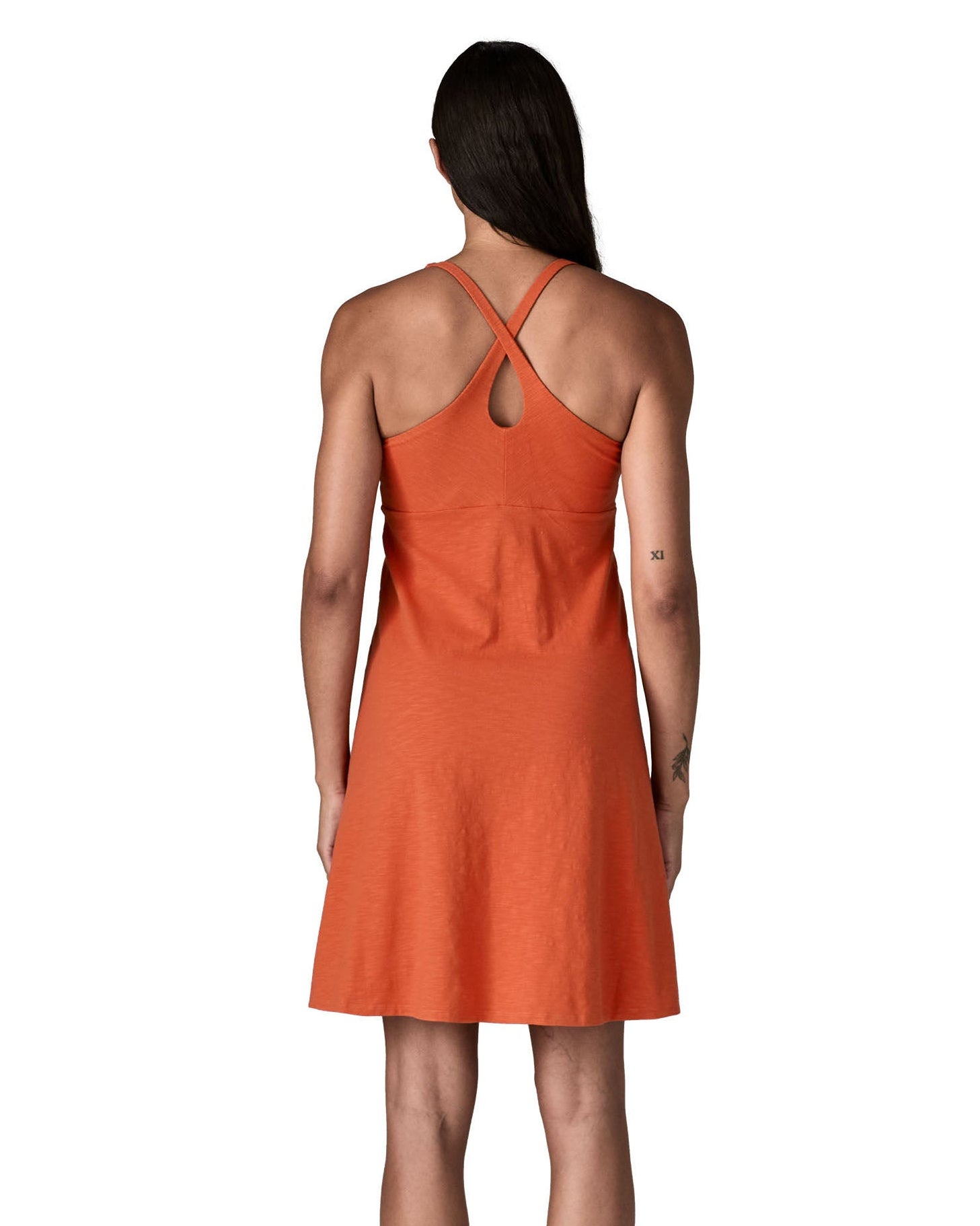 Back of woman wearing Patagonia's amber dawn sleeveless dress in orange.  Dress is slim fit and classic knee-height