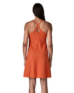 Back of woman wearing Patagonia's amber dawn sleeveless dress in orange.  Dress is slim fit and classic knee-height