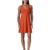 Woman wearing Patagonia's amber dawn sleeveless dress in orange.  Dress  has front low v neck and knee-height