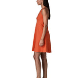 Side of woman wearing Patagonia's amber dawn sleeveless dress in orange.  Dress is slim fit and classic knee-height