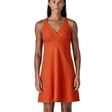 Front of woman wearing Patagonia's amber dawn organic cotton sleeveless dress in orange. Dress is slim fit 