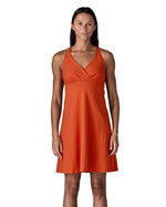 Front of woman wearing Patagonia's amber dawn organic cotton sleeveless dress in orange. Dress is slim fit 