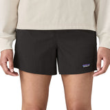 Woman wearing Patagonia quick drying women's baggies shorts in black. Shorts have a loose fit