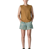 Woman wearing Patagonia quick drying women's baggies shorts in light blue with repeating abstract design with hands in side pockets