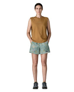 Woman wearing Patagonia quick drying women's baggies shorts in light blue with repeating abstract design with hands in side pockets