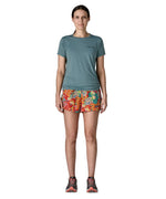 Woman wearing Patagonia quick drying women's baggies shorts in red with repeating abstract design. Shorts have loose fit