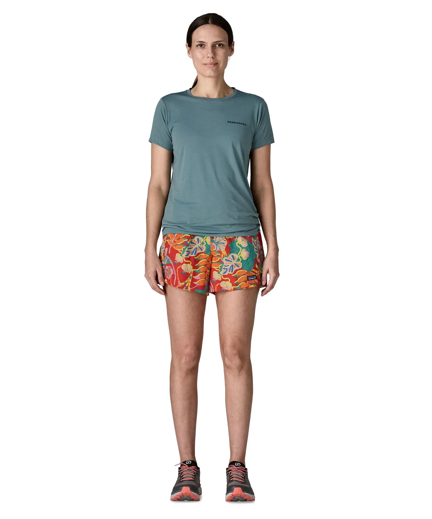 Woman wearing Patagonia quick drying women's baggies shorts in red with repeating abstract design. Shorts have loose fit