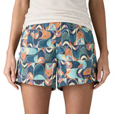 Woman wearing Patagonia quick drying  baggies shorts in blue with a repeating abstract design. 