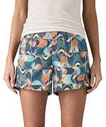 Woman wearing Patagonia quick drying  baggies shorts in blue with a repeating abstract design. 