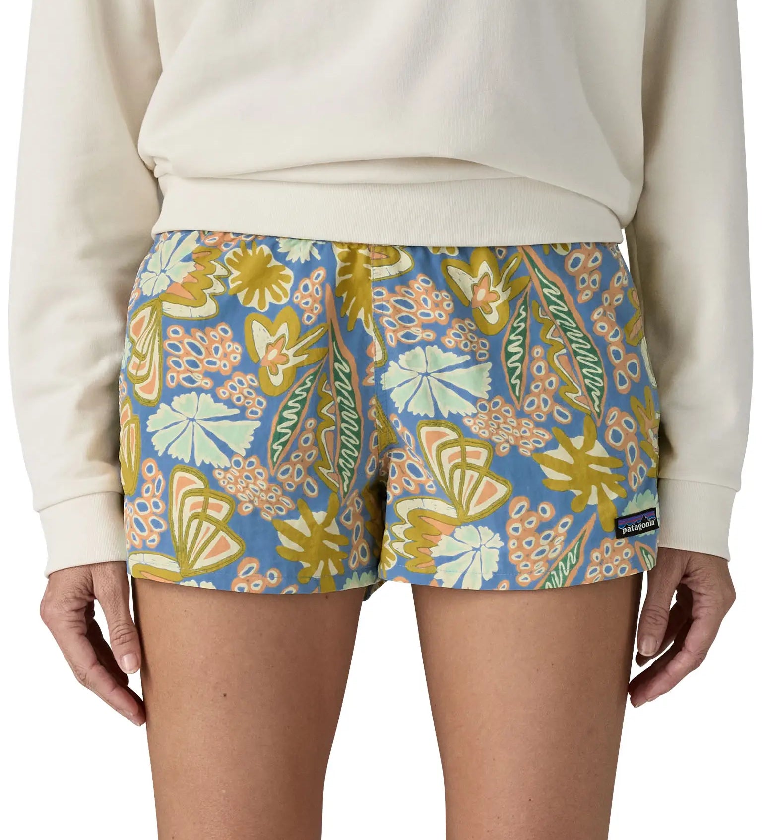 Front of woman wearing the Patagonia quick drying barely baggies shorts in blue with a repeating abstract floral design