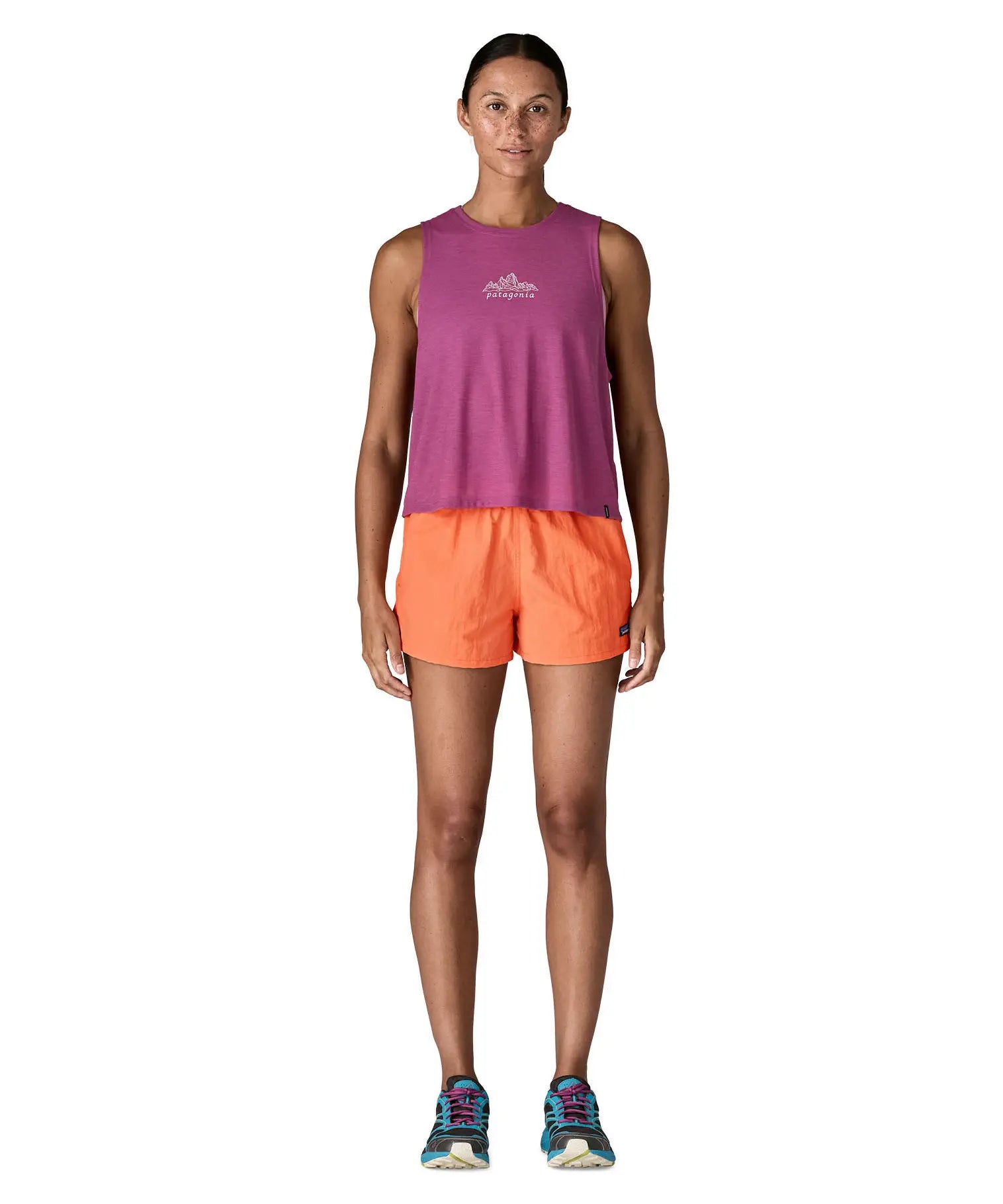 Woman wearing Patagonia's quick drying women's barely baggies shorts in bright orange 