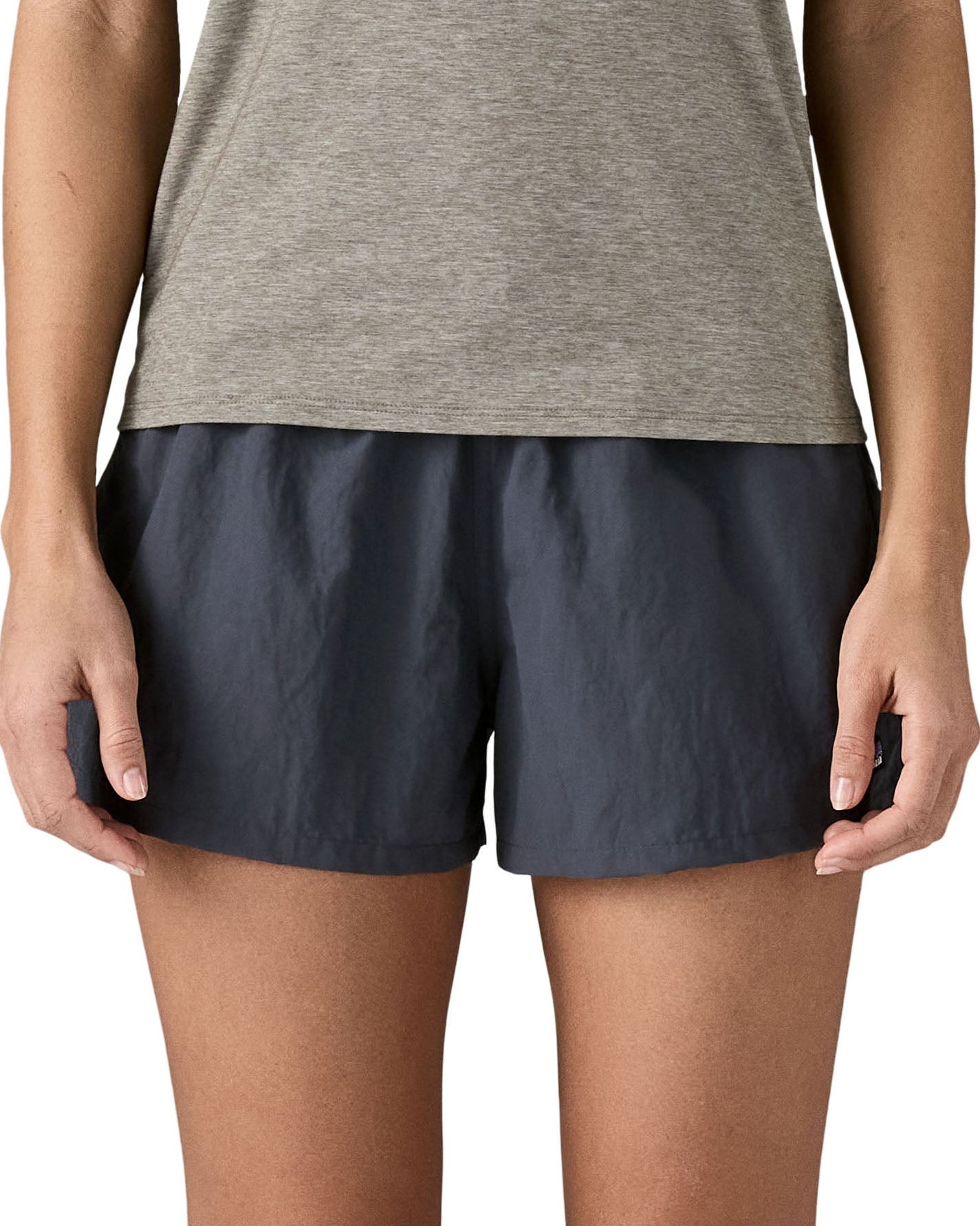 Front of woman wearing Patagonia'squick drying women's barely baggies shorts in navy blue. Shorts have a loose fit