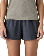 Front of woman wearing Patagonia'squick drying women's barely baggies shorts in navy blue. Shorts have a loose fit