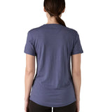 Back of Woman wearing Patagonia's capilene merino blend short sleeve technical t-shirt in solstice purple showing curved hem