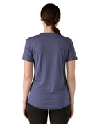 Back of Woman wearing Patagonia's capilene merino blend short sleeve technical t-shirt in solstice purple showing curved hem