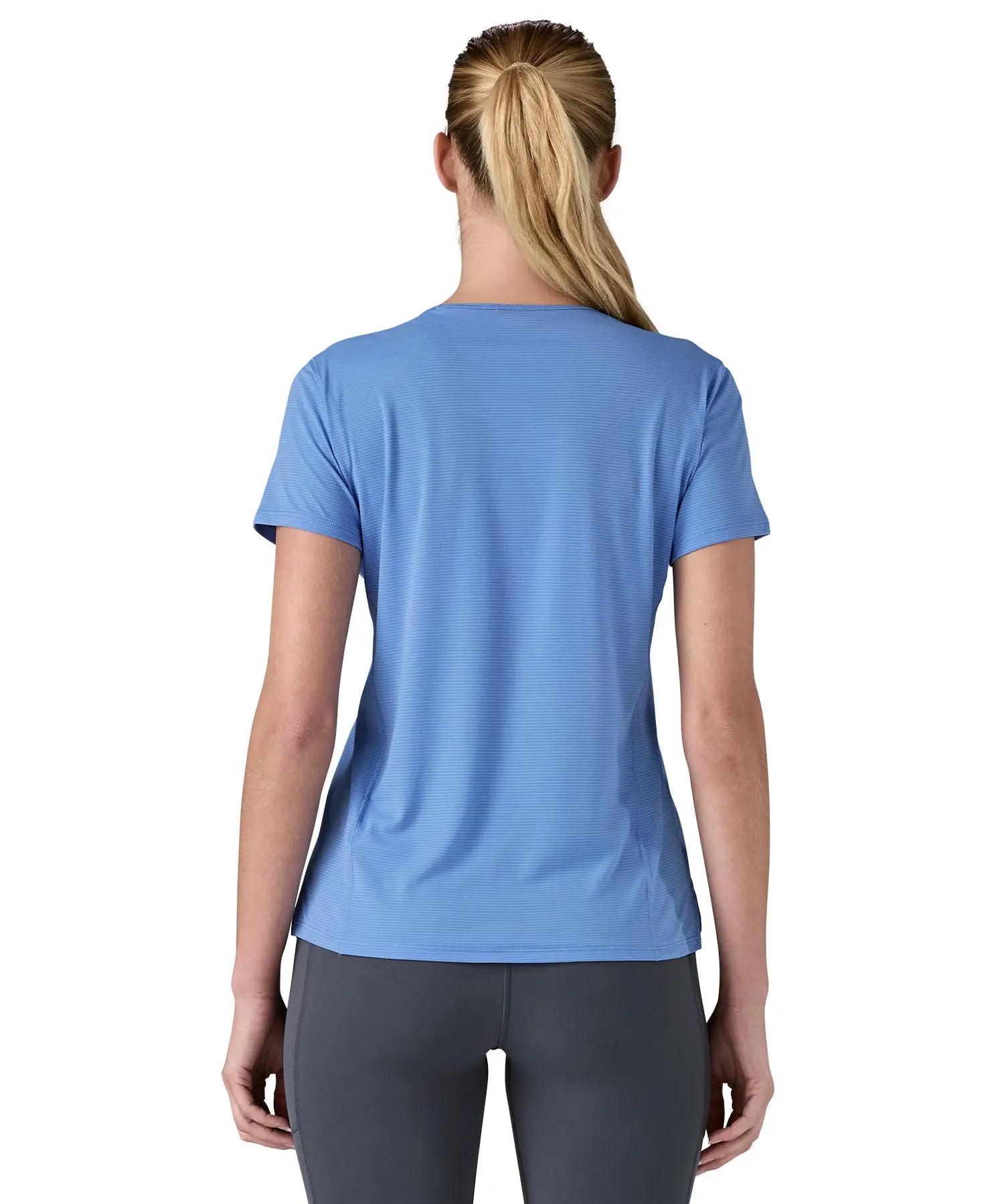 Back of woman wearing Patagonia's technical capilene cool lightweight t-shirt in light blue. 