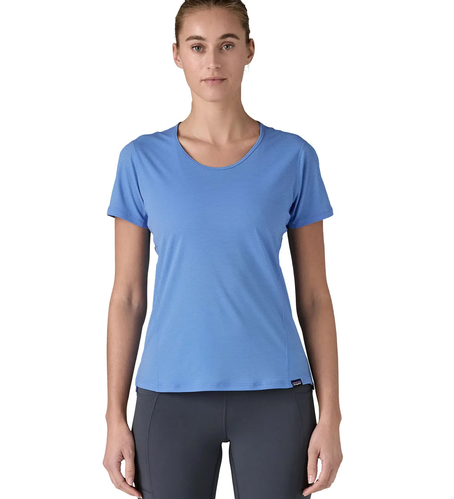 Woman wearing Patagonia's technical capilene cool lightweight t-shirt in light blue. Top has a slim fit