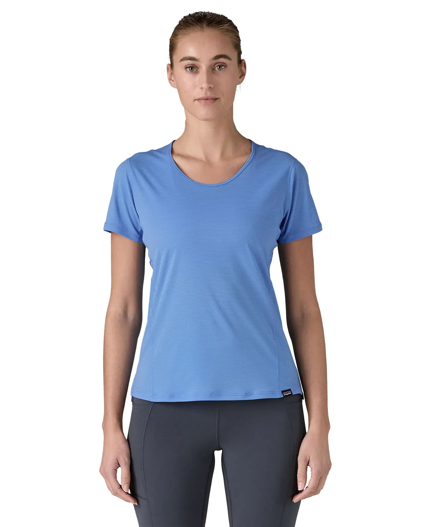 Woman wearing Patagonia's technical capilene cool lightweight t-shirt in light blue. Top has a slim fit