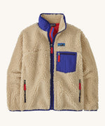 A Patagonia women's classic retro-x jacket in a dark natural colour way available at Babipur. A thick fleece with royal blue trim detail with a full length zip, 2 side pockets and a chest pocket with the logo patch stitched above.