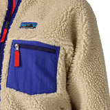 A close up of the A Patagonia women's classic retro-x jacket in a dark natural colour way available at Babipur showing the royal blue zipped chest pocket detail