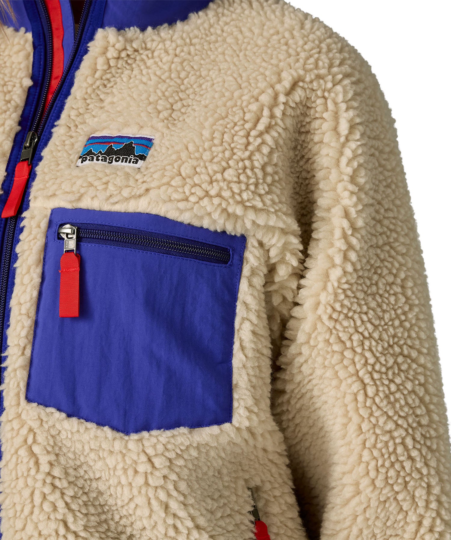A close up of the A Patagonia women's classic retro-x jacket in a dark natural colour way available at Babipur showing the royal blue zipped chest pocket detail