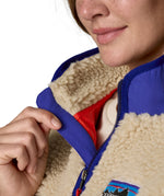 A close up of the A Patagonia women's classic retro-x jacket in a dark natural colour way available at Babipur showing the royal blue zip trim detail