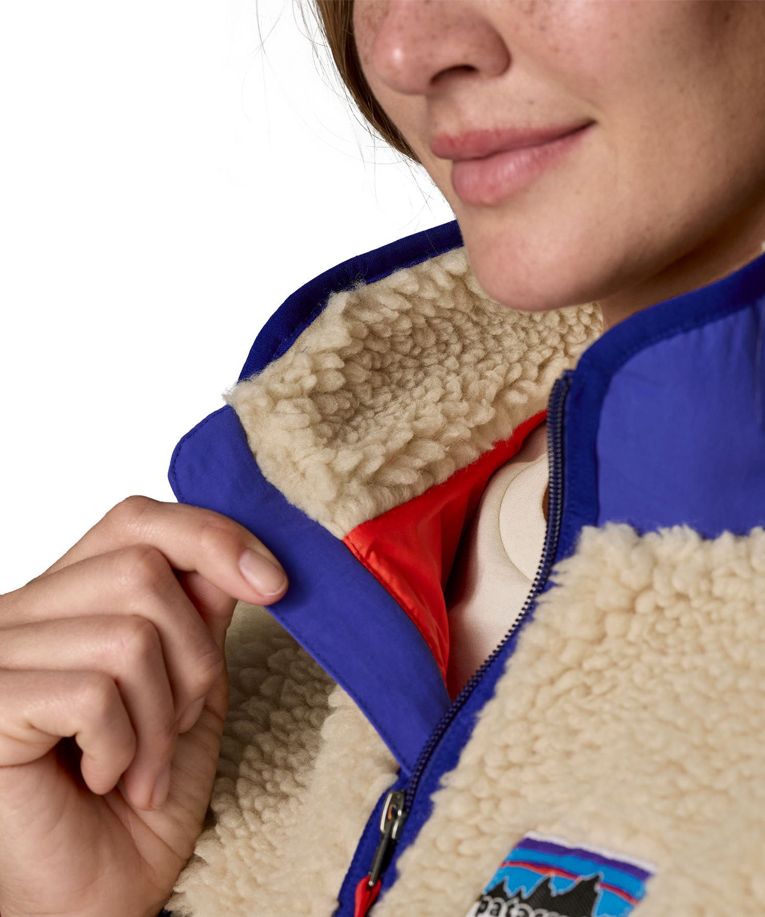 A close up of the A Patagonia women's classic retro-x jacket in a dark natural colour way available at Babipur showing the royal blue zip trim detail