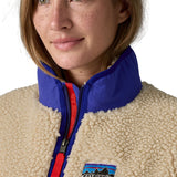 A close up of the A Patagonia women's classic retro-x jacket in a dark natural colour way available at Babipur showing the royal blue turn up collar detail