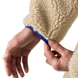 A close up of the A Patagonia women's classic retro-x jacket in a dark natural colour way available at Babipur showing the royal blue turn cuff trim 