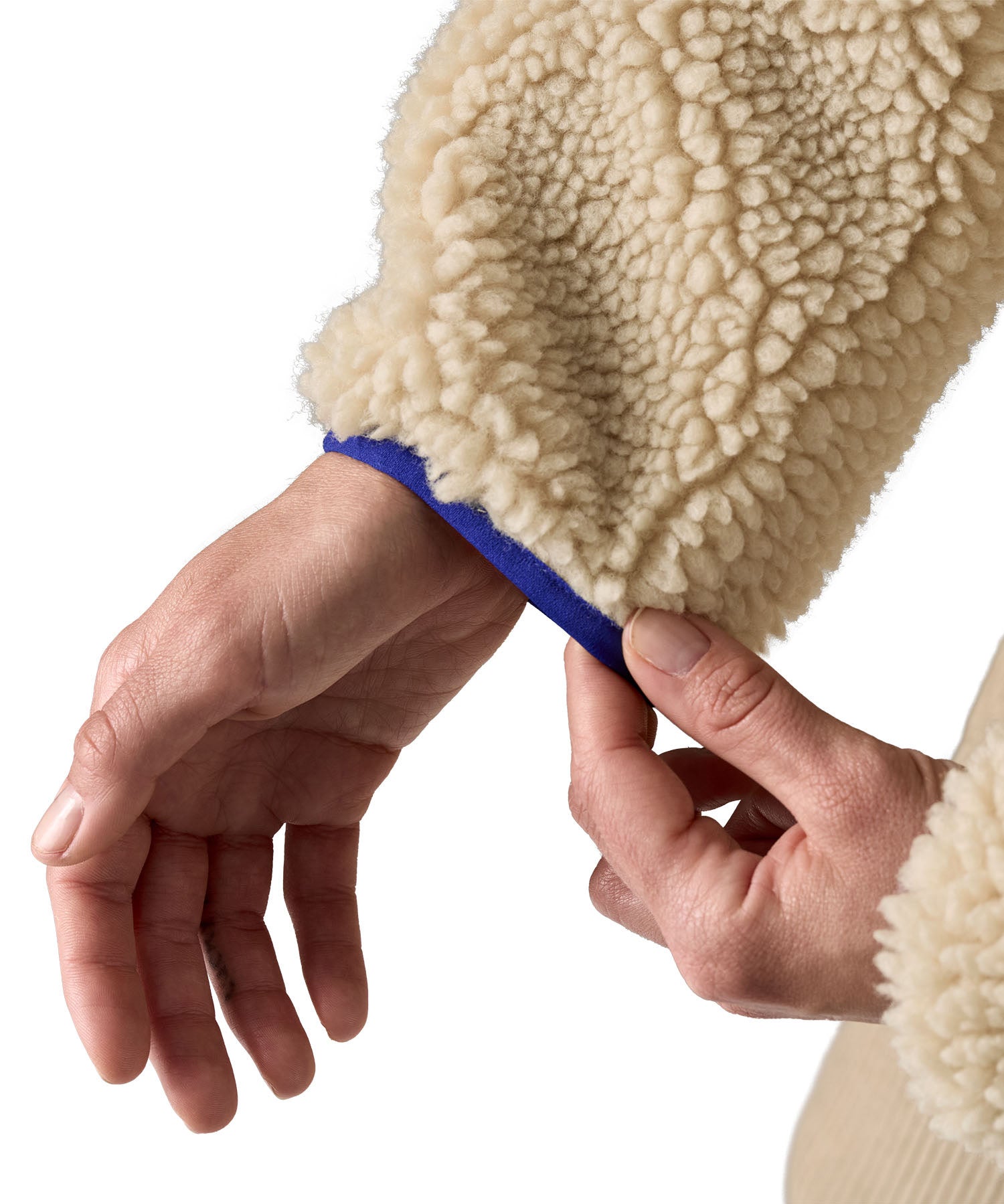 A close up of the A Patagonia women's classic retro-x jacket in a dark natural colour way available at Babipur showing the royal blue turn cuff trim 