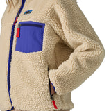 An image of a women wearing the Patagonia women's classic retro-x jacket in a dark natural colour way available at Babipur showing the thick fleece detail