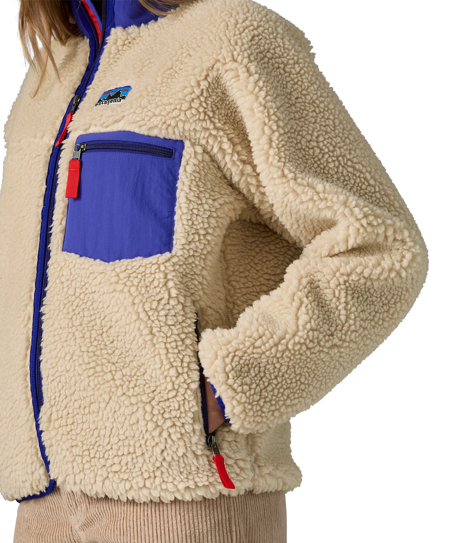 An image of a women wearing the Patagonia women's classic retro-x jacket in a dark natural colour way available at Babipur showing the thick fleece detail