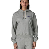 Woman wearing Patagonia's daily hoody in grey showing the kangaroo pouch pocket. Hoody has a relaxed fit and sits around the hips