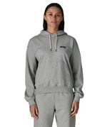 Woman wearing Patagonia's daily hoody in grey showing the kangaroo pouch pocket. Hoody has a relaxed fit and sits around the hips