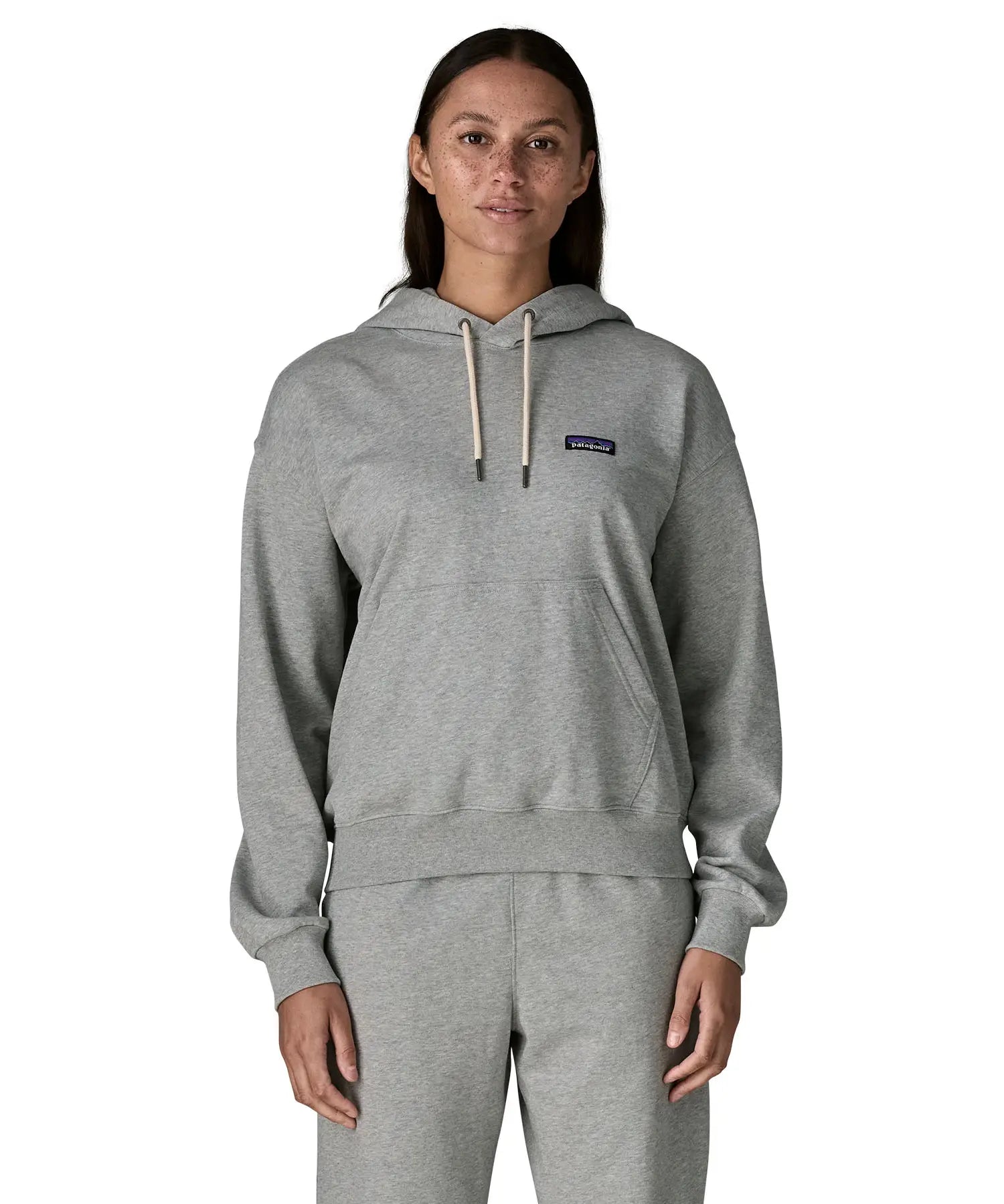 Woman wearing Patagonia's daily hoody in grey showing the kangaroo pouch pocket. Hoody has a relaxed fit and sits around the hips