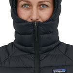 A person wearing the Patagonia Women's Down Sweater Hoody, showing how the zip goes past the chin to keep the face warm