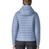Back of woman wearing the Patagonia down insulated sweater hoody jacket in barnacle blue.