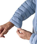 Woman wearing the Patagonia down insulated sweater hoody in barnacle blue showing close up of cuff trim