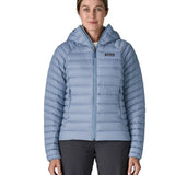 Woman wearing the Patagonia down insulated sweater hoody in barnacle blue fully zipped. Jacket has a regular fit