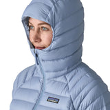 Woman wearing the Patagonia down insulated sweater hoody in barnacle blue showing close up of snug fit hood