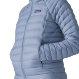 Woman wearing the Patagonia down insulated sweater hoody in barnacle blue showing close up of the side pocket
