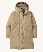 Patagonia womens downdrift parka jacket ir oar tan available at Babipur. A long length padded jacket in cream. Features a hood, full length zip with popper fastener and 2 side pockets