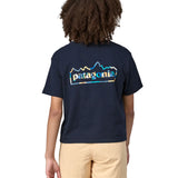 Back of Woman wearing Patagonia women's unity Fitz roy responsibili short sleeve tshirt in navy blue.