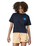 Woman wearing Patagonia women's unity Fitz roy responsibili short sleeve tshirt in navy  blue. Top has a boxy fit