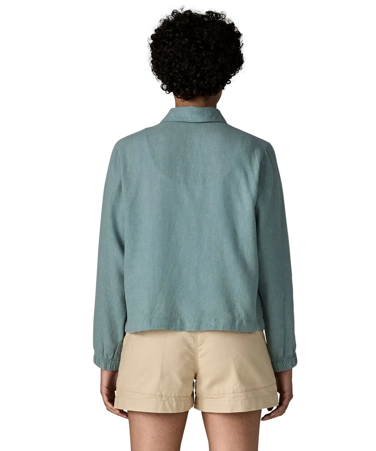 Back of woman wearing Patagonia women's lightweight jacket in blue. Jacket has a boxy fit and sits at the hips