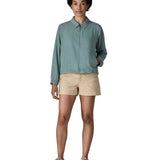 Woman wearing Patagonia women's lightweight jacket in blue. Features a full length front zip and side pockets. Jacket has a boxy fit and sits at the hips